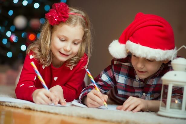 Deux enfants rédigent leur lettre au Père Noël