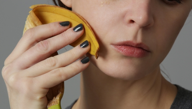 Femme frottant une pelure de banane sur son visage