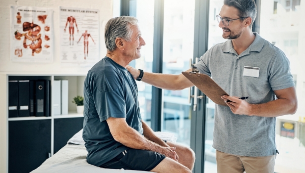 Ostéopathe examinant un patient senior assis sur une table de consultation en cabinet