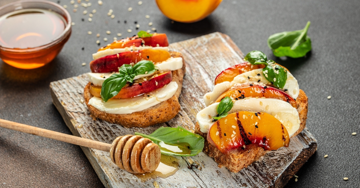 Une tartine sucrée-salée aux pêches, au prosciutto et aux épinards.