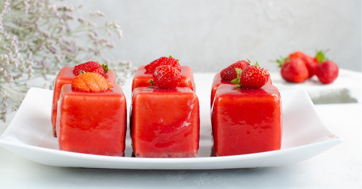  Dessert de fraise sur une assiette blanche. Mousse de fraise à la gelée rouge. Des bonbons sains. gros plan.