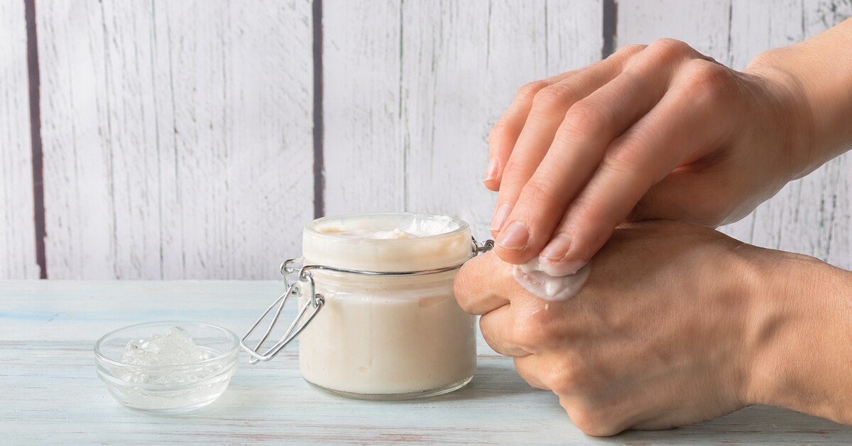 Personne appliquant un soin après-soleil maison, avec un bol de gel d'aloe vera frais.